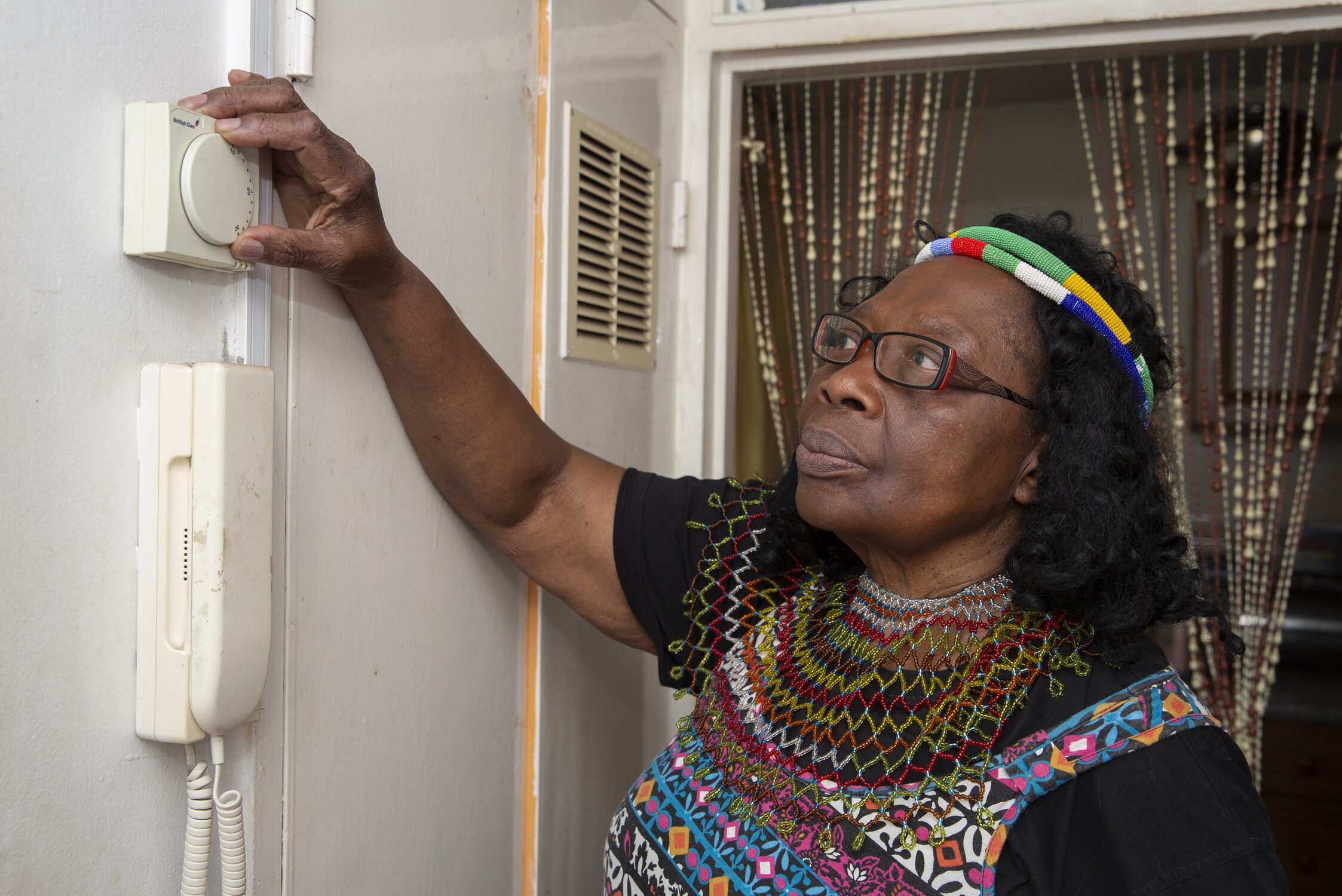 Lady turning down thermostat