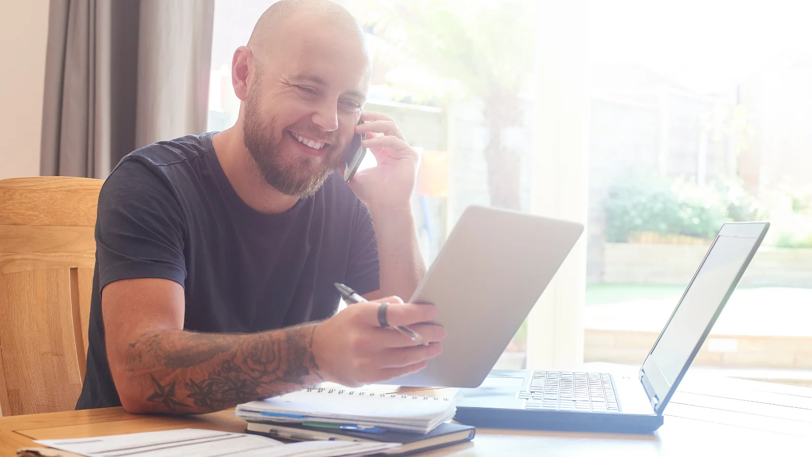 Man on phone whilst looking at notepad