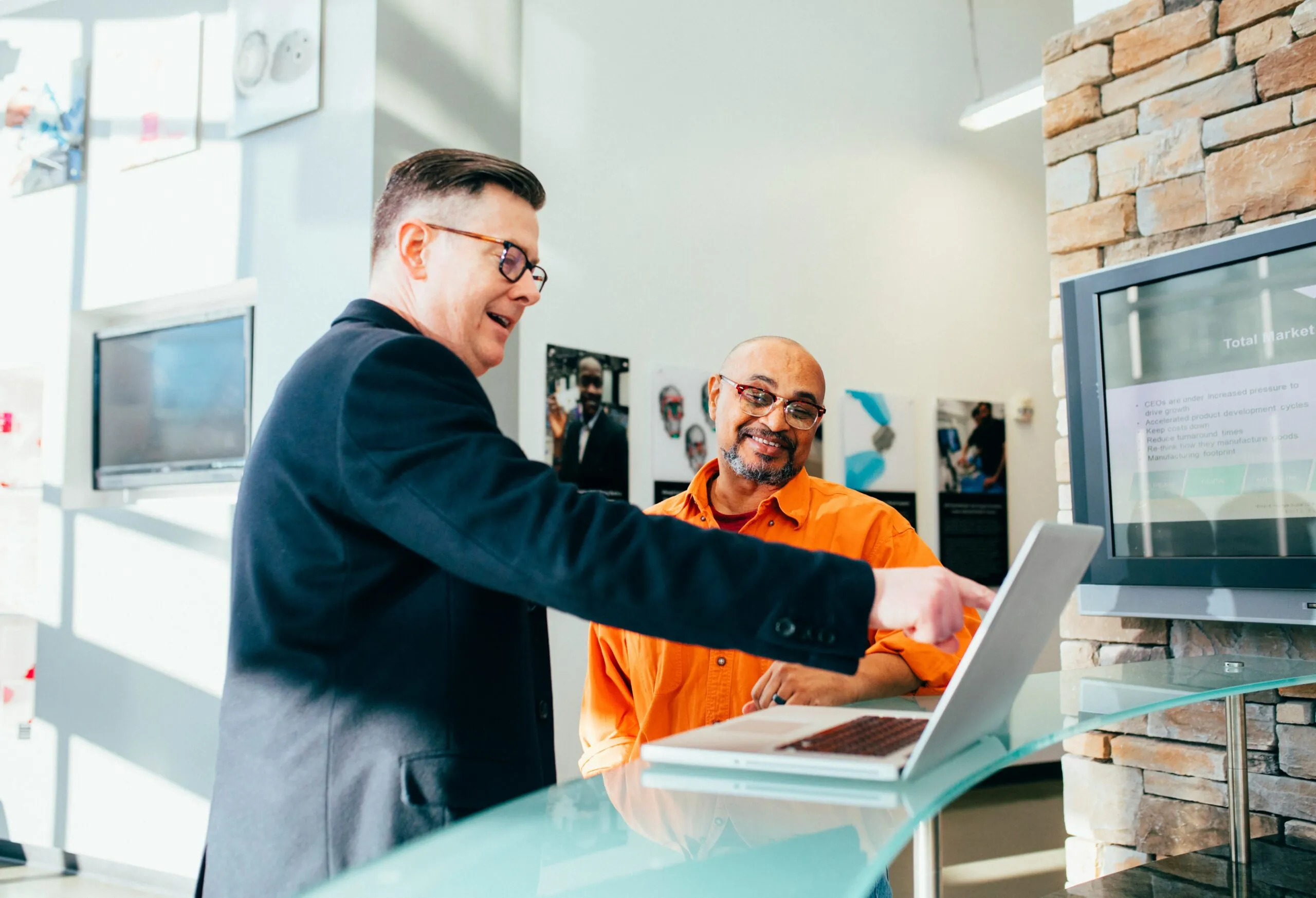 Two men working on computer together