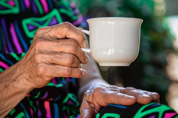 photo of older person's hands holding a tea cup to illustrate a blog post on the Health and Social Care Levy