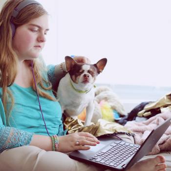 Woman and dog at home on laptop