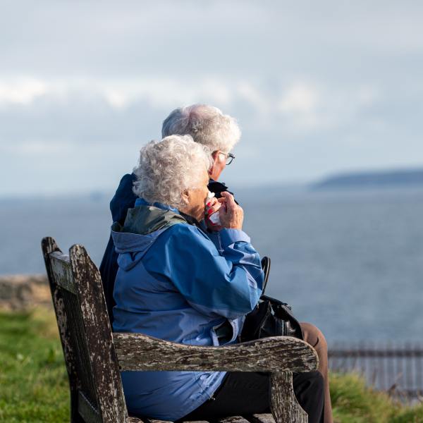 Photo of two older people on a bench to illustrate pensioner poverty