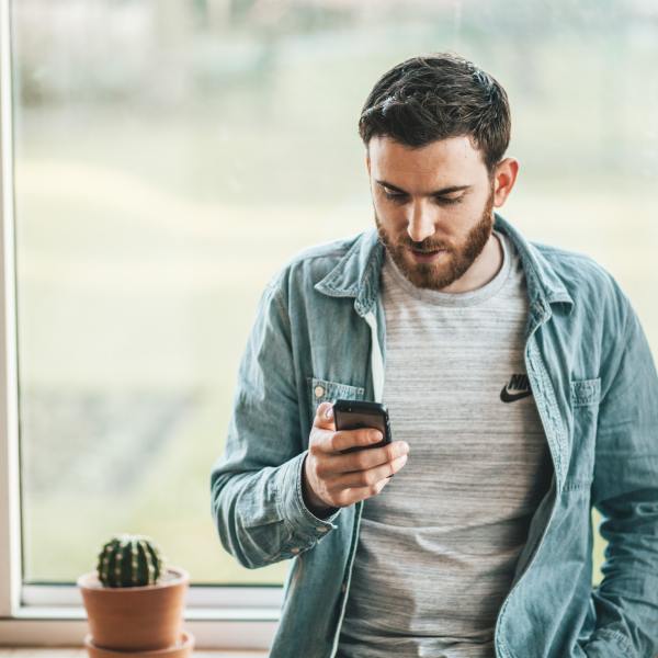 Man looking at phone - policy in practice blog